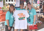 Weatherford Chamber of Commerce volunteers Wenday Davis, Stacy Cliver, and Molly Michel display a Peach Festival t-shirt.